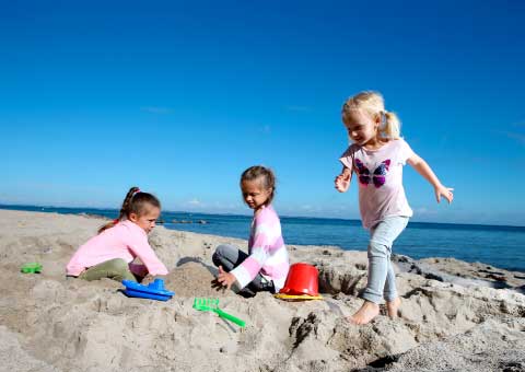Kinder spielen am Strand mit Sand 